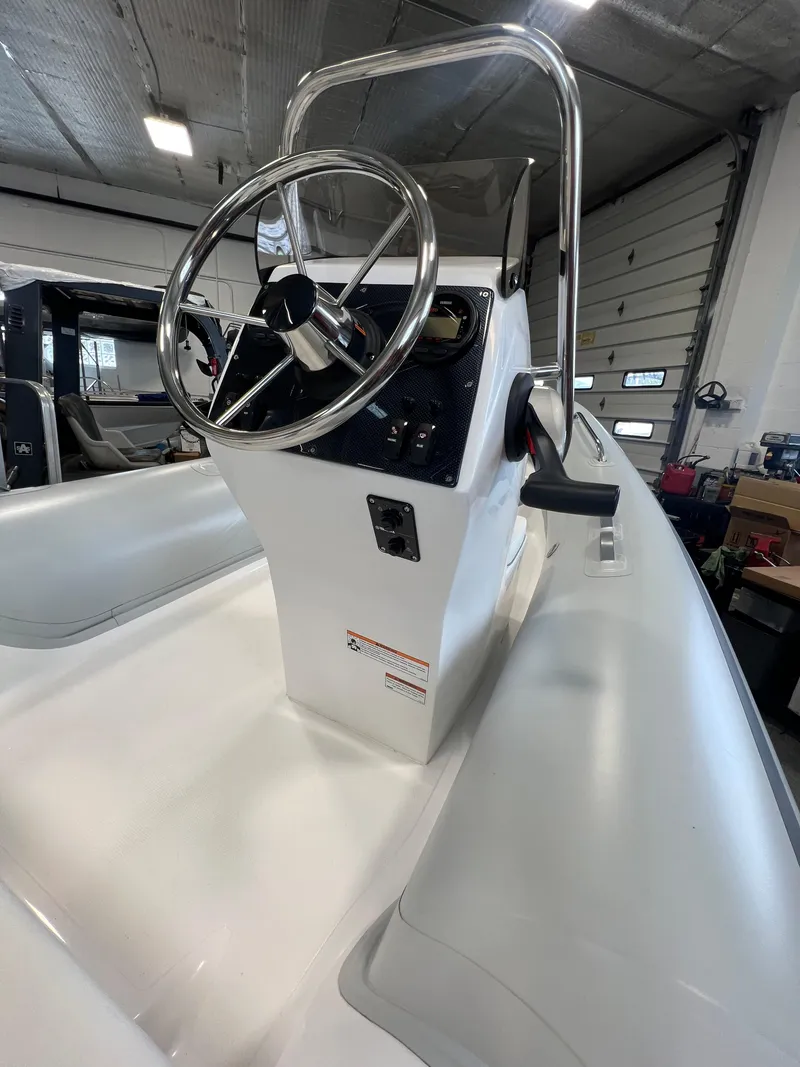 Slide: The Image of 2024 AB Inflatables 15 OCEANUS VST boat console with steering wheel in a showroom. - 3