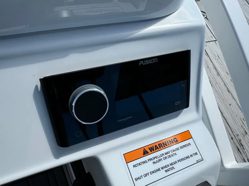 Slide: The Image of 2024 JC Neptoon Sport 23TT DSL boat control panel with Fusion stereo and safety warning label. - 21