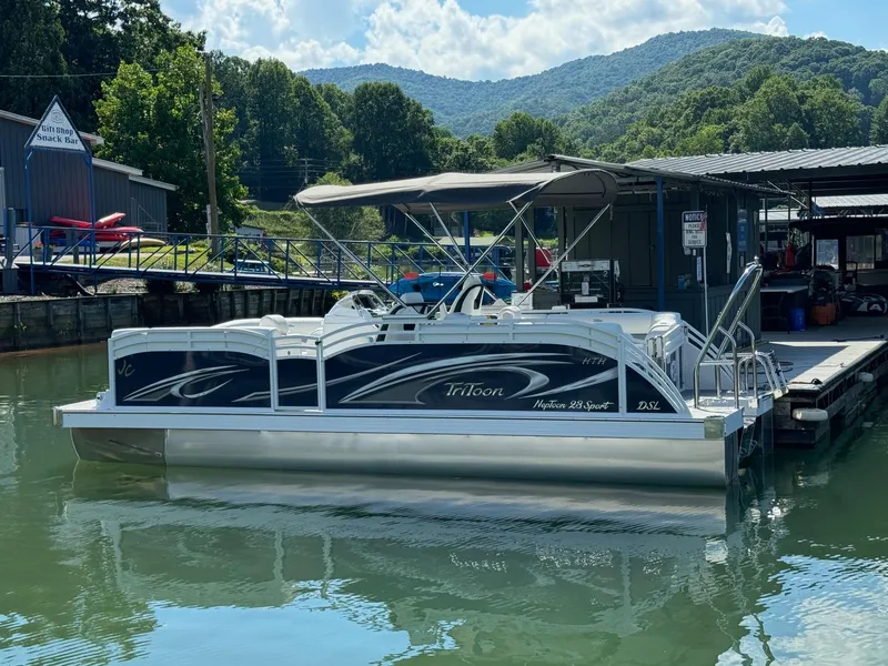 Slide: The Image of 2024 JC Neptoon Sport 23TT DSL pontoon boat docked on a sunny day. - 3