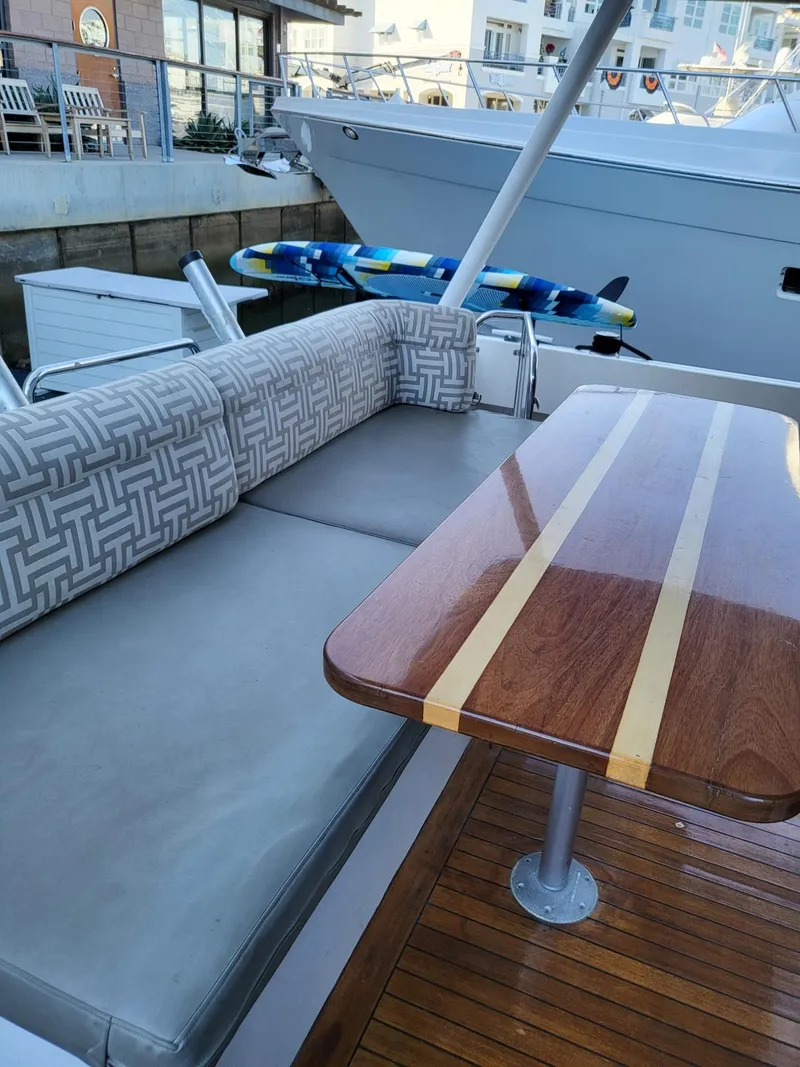 Slide: The Image of 2005 Pacific Mariner 65 SE Motoryacht with elegant outdoor seating and polished wooden table. - 12