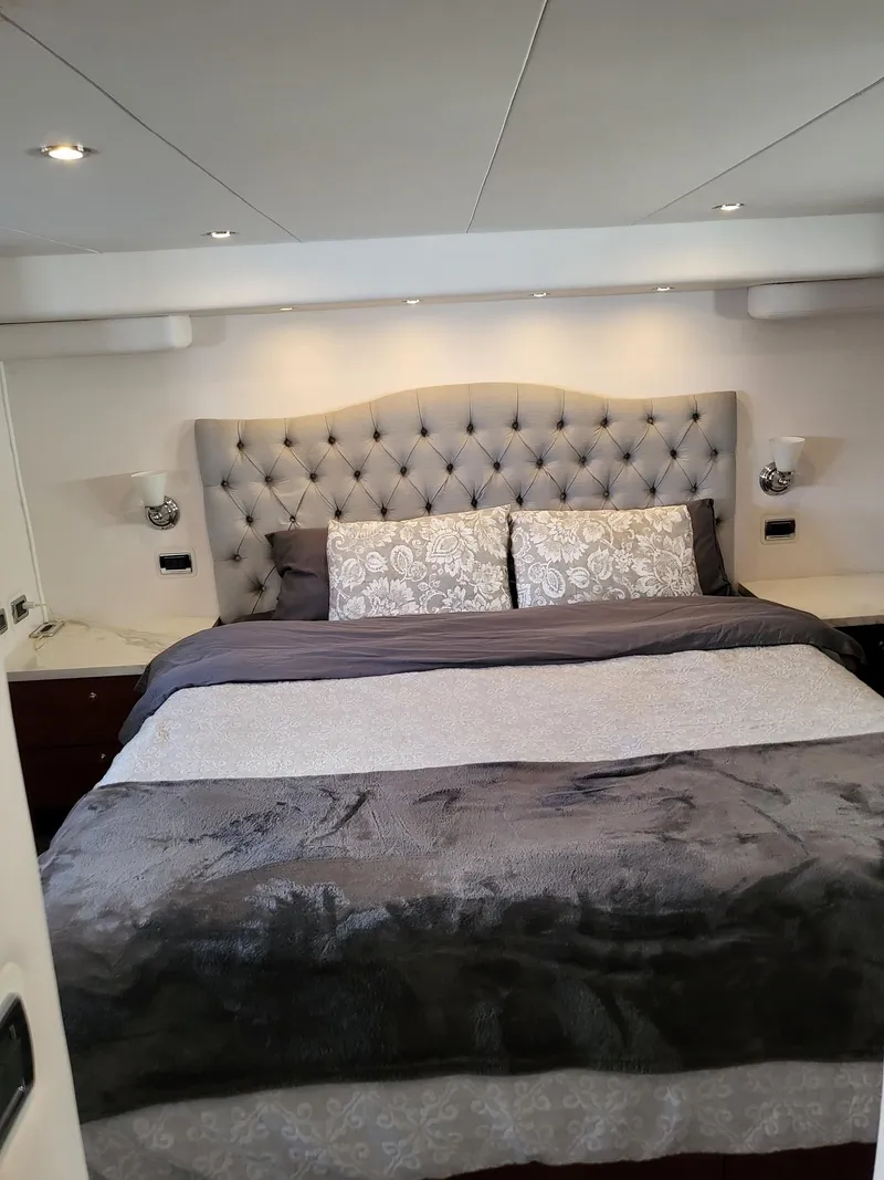Slide: The Image of Luxurious bedroom in 2005 Pacific Mariner 65 SE Motoryacht with elegant bedding and tufted headboard. - 15