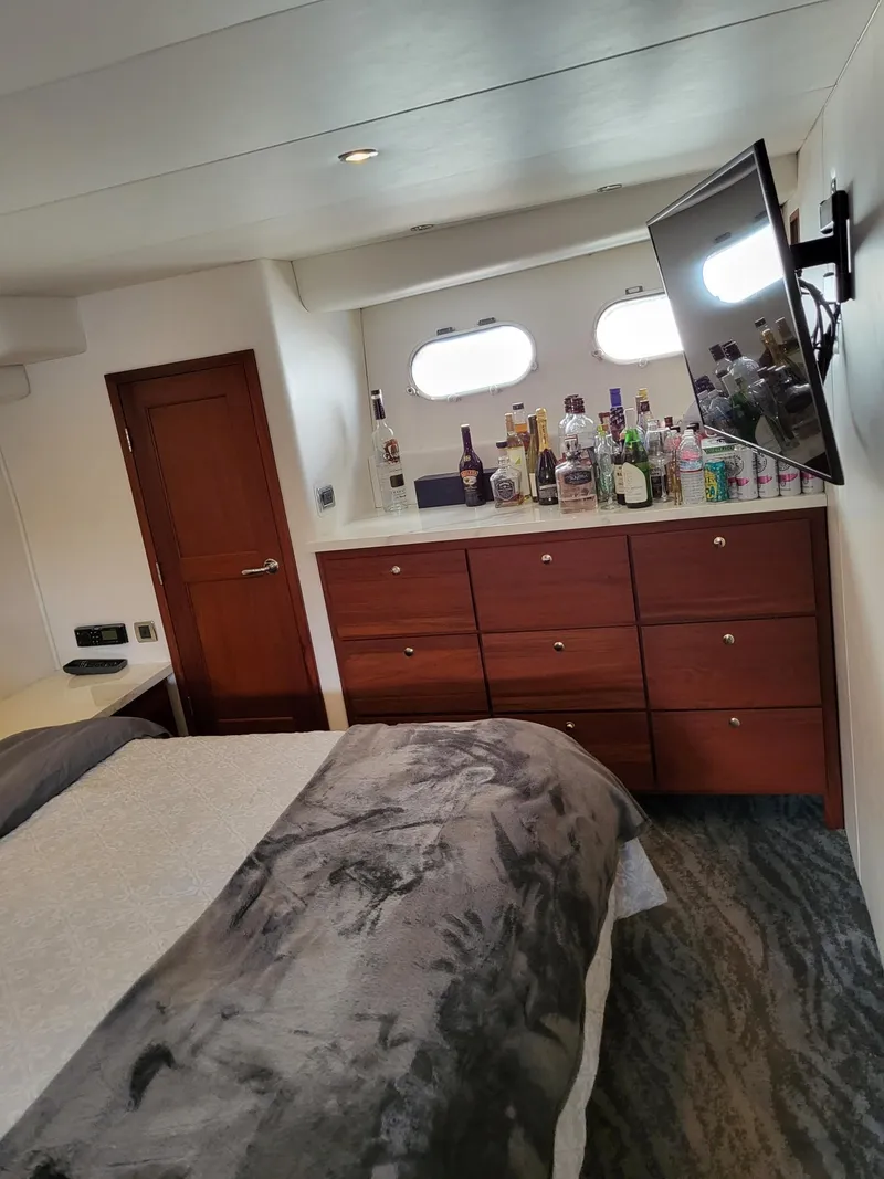Slide: The Image of Luxurious bedroom in 2005 Pacific Mariner 65 SE Motoryacht with TV and bar setup. - 16