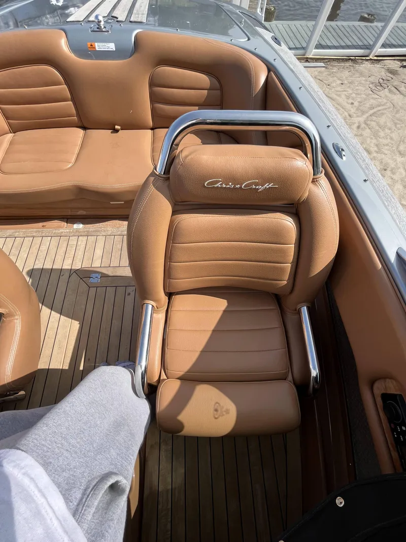 Slide: The Image of 2011 Chris-Craft Silver Bullet 20 boat with tan leather seats and wooden deck. - 11