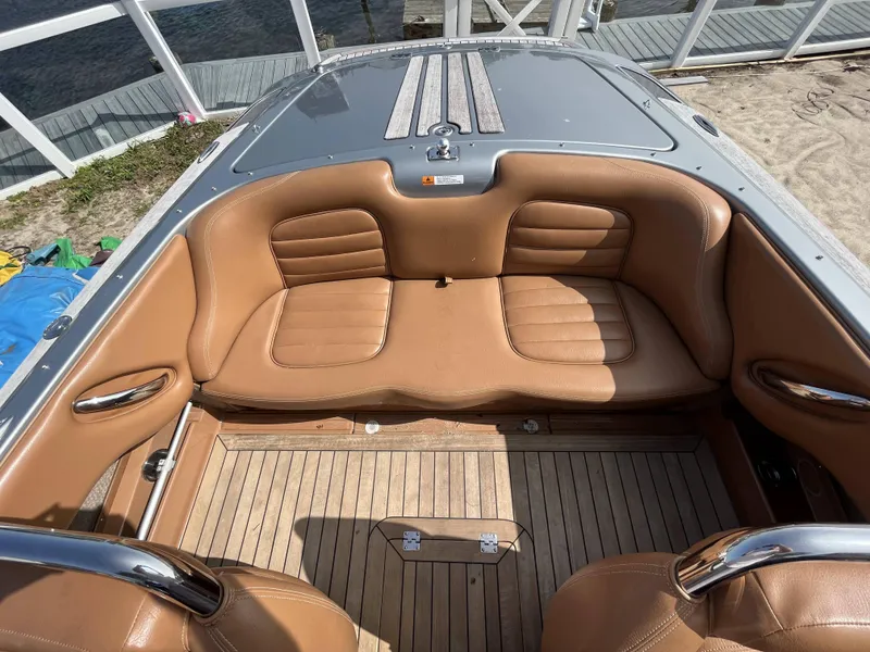 Slide: The Image of 2011 Chris-Craft Silver Bullet 20 boat interior with tan leather seats and wooden flooring. - 15