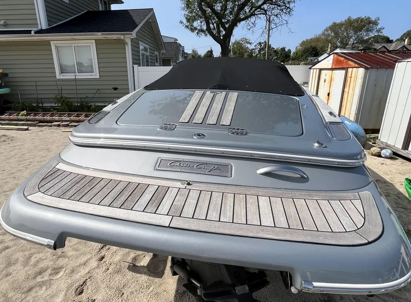 Slide: The Image of 2011 Chris-Craft Silver Bullet 20 boat with covered deck, parked on sandy ground. - 5