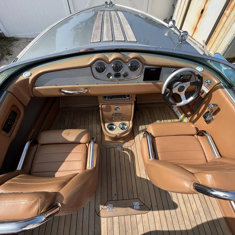 Slide: The Image of 2011 Chris-Craft Silver Bullet 20 interior with tan leather seats and wooden dashboard. - 7