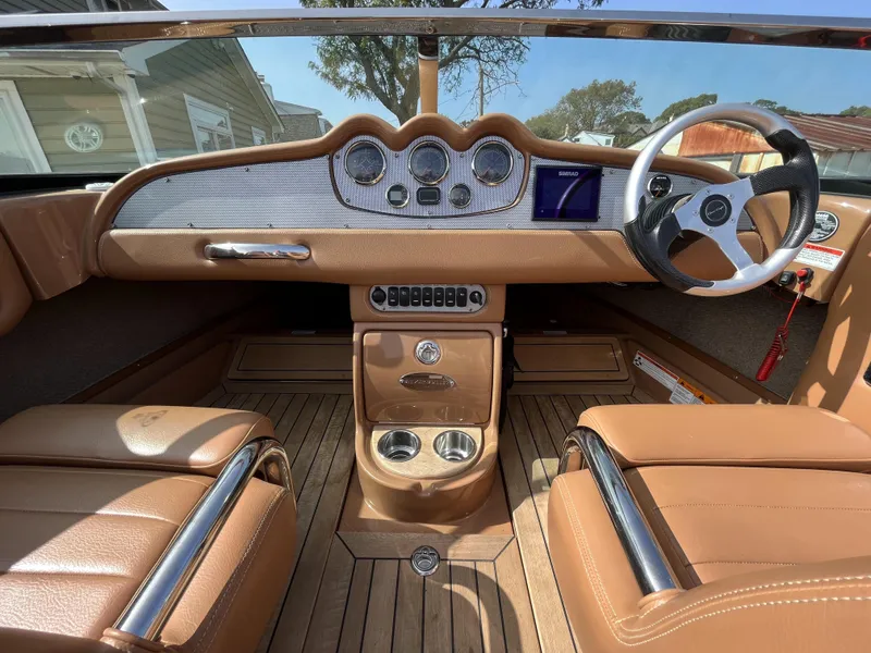 Slide: The Image of 2011 Chris-Craft Silver Bullet 20 boat interior with tan leather seats and wooden dashboard. - 8