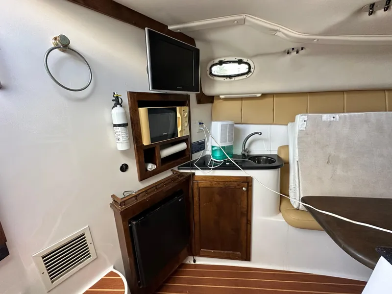Slide: The Image of 2008 ProKat 3660 Sport Fish interior with kitchenette, TV, microwave, and sink. - 19