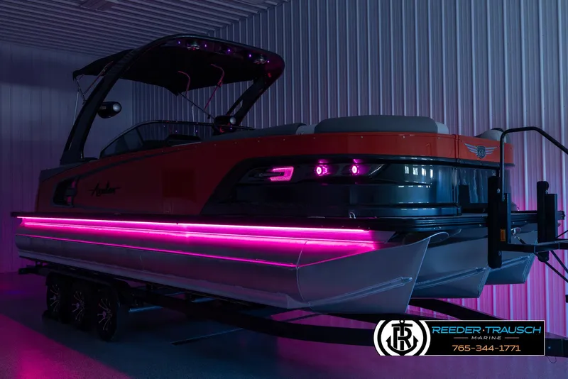 Slide: The Image of 2024 Avalon 2785 Excalibur EL pontoon boat with vibrant pink LED lights in a showroom. - 4