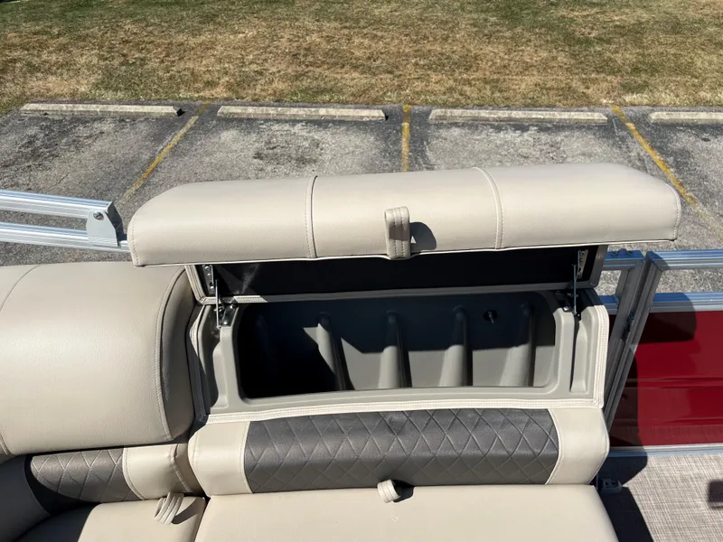 Slide: The Image of 2024 Sun Tracker Party Barge 22 RF XP3 storage compartment with open seat cushion. - 13