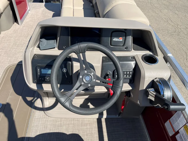 Slide: The Image of 2024 Sun Tracker Party Barge 22 RF XP3 steering console with controls and cup holder. - 5