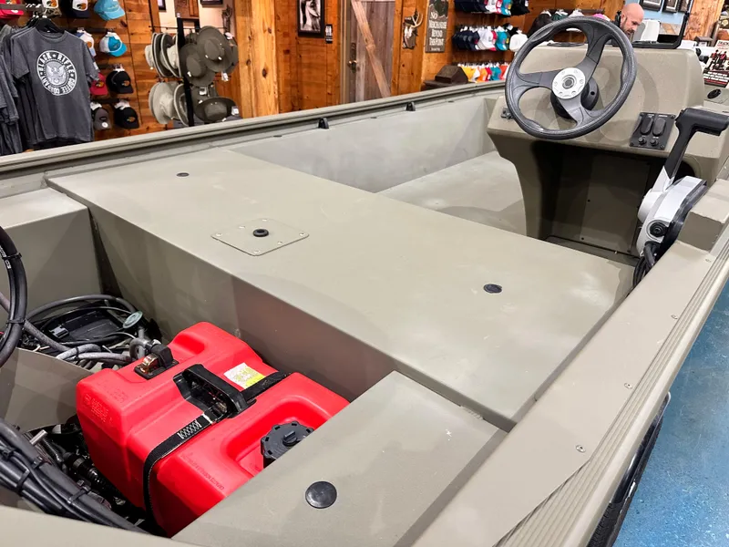 Slide: The Image of 2024 Tracker Grizzly 1648 SC boat interior with steering wheel and red fuel tank. - 32