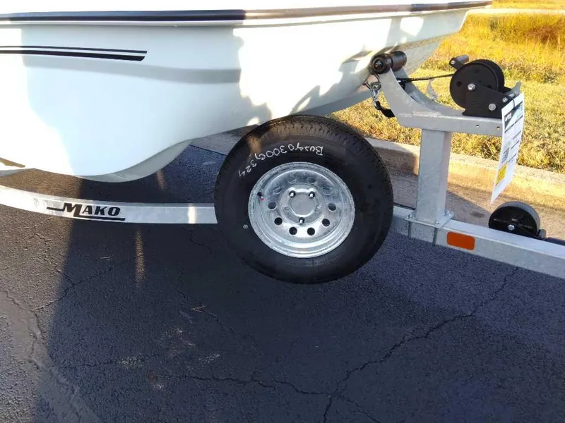 Slide: The Image of 2024 Mako Pro Skiff 15 CC on trailer, close-up of wheel and hull. - 4