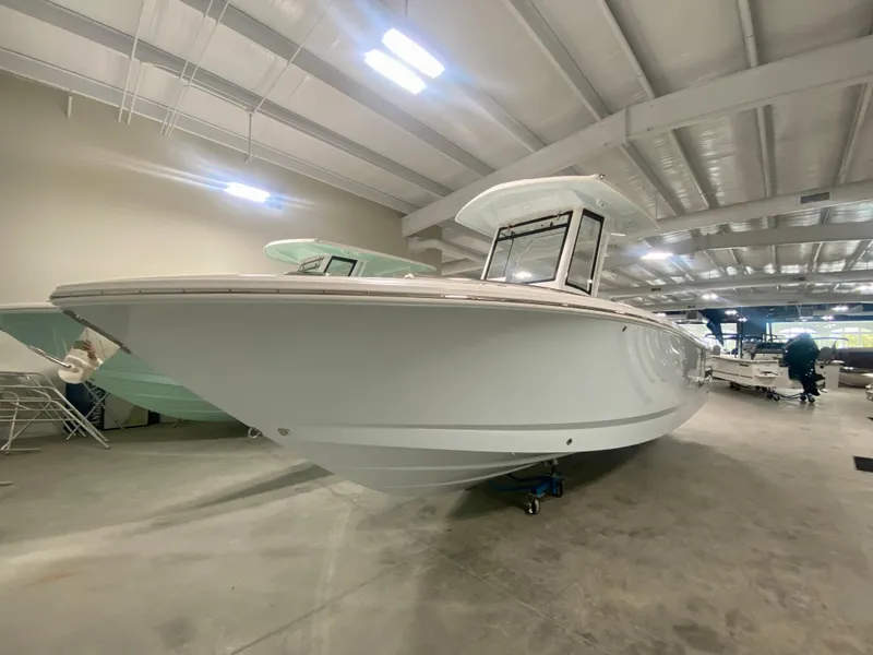 Slide: The Image of 2024 Robalo R250 boat in showroom, side view. - 1