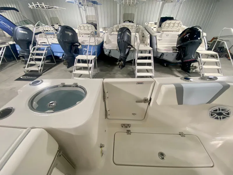 Slide: The Image of 2024 Robalo R250 boat interior with Yamaha outboard engines in showroom. - 11