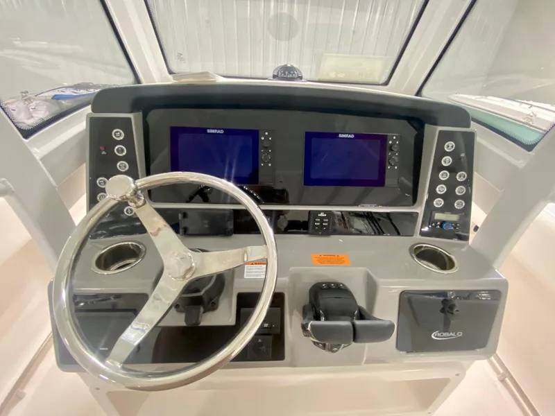 Slide: The Image of 2024 Robalo R250 boat dashboard with dual Simrad displays and stainless steel steering wheel. - 20