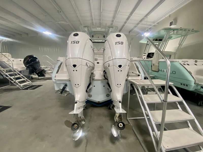 Slide: The Image of 2024 Robalo R250 boat with twin 150 HP engines in a showroom. - 3