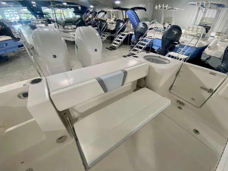 Slide: The Image of 2024 Robalo R250 boat interior with seating and twin engines in showroom. - 9