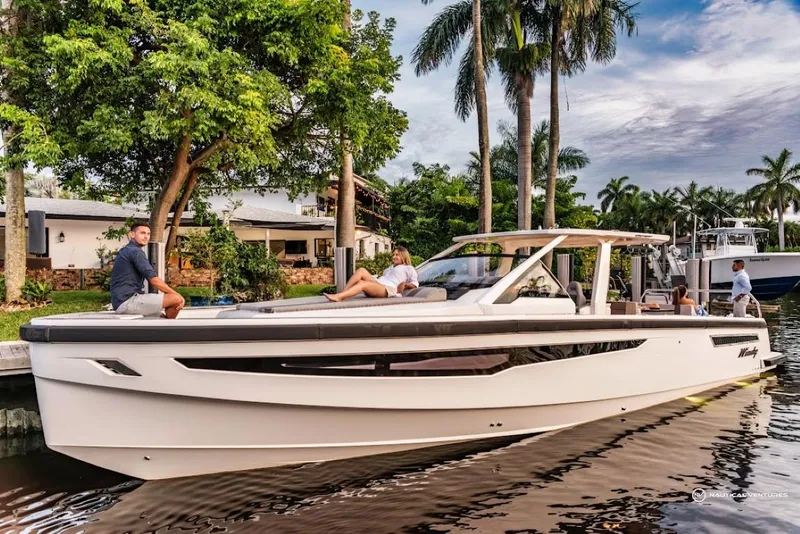 Slide: The Image of 2022 Windy SR44 SX luxury yacht docked near palm trees and waterfront homes. - 0
