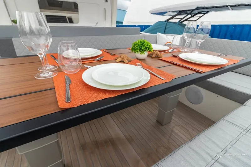 Slide: The Image of Elegant dining setup on the 2022 Windy SR44 SX yacht with orange placemats and glassware. - 22
