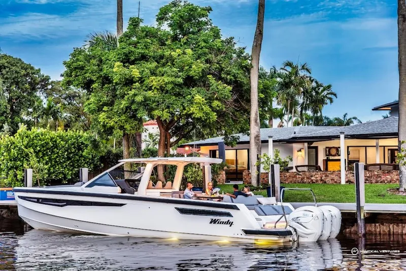 Slide: The Image of 2022 Windy SR44 SX boat docked near a waterfront home. - 11