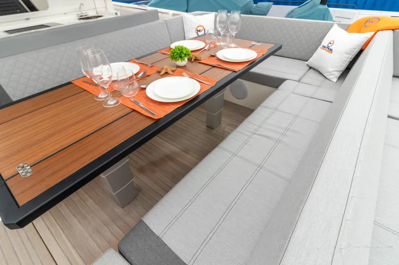 Slide: The Image of 2022 Windy SR44 SX boat interior dining area with wooden table and gray seating. - 18