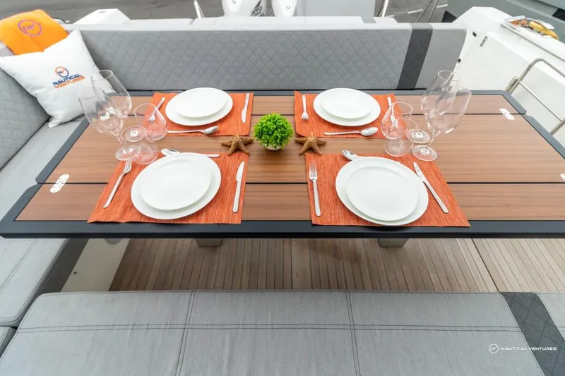 Slide: The Image of Elegant dining setup on Windy SR44 SX 2022 yacht with orange placemats and white plates. - 21