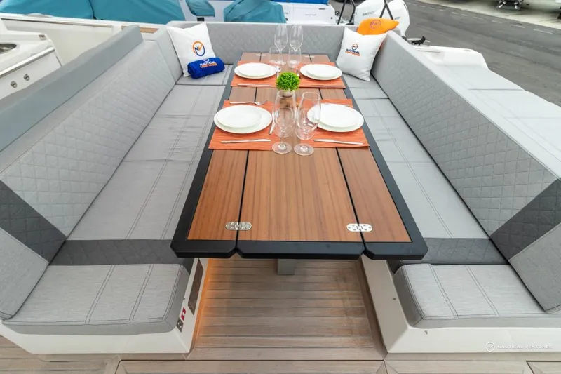 Slide: The Image of 2022 Windy SR44 SX yacht dining area with elegant table setting and cushioned seating. - 23