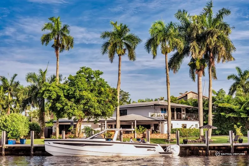 Slide: The Image of 2022 Windy SR44 SX boat cruising near waterfront homes with palm trees. - 3