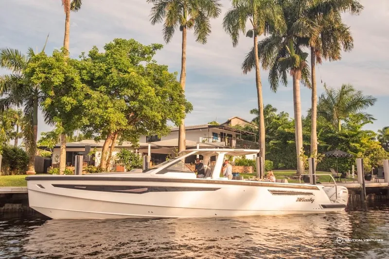 Slide: The Image of 2022 Windy SR44 SX boat cruising near a tropical waterfront home. - 5