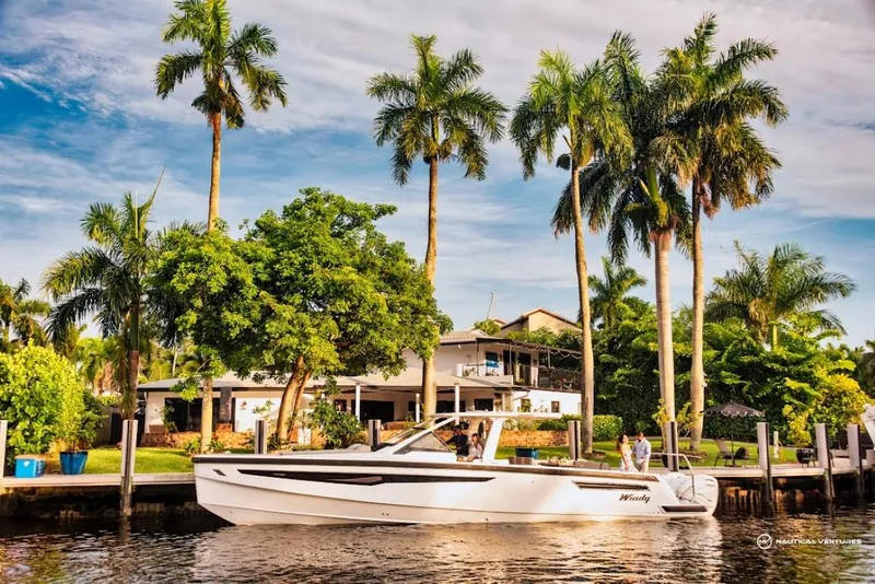 Slide: The Image of 2022 Windy SR44 SX boat docked near a tropical waterfront home with palm trees. - 6
