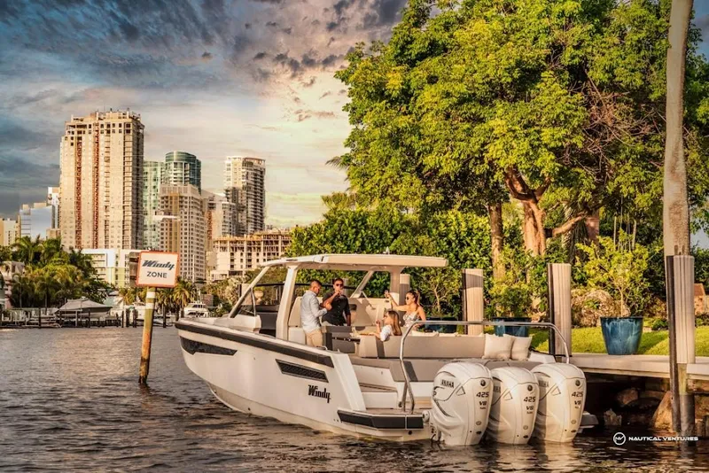 Slide: The Image of 2022 Windy SR44 SX boat docked near city skyline and lush greenery. - 7