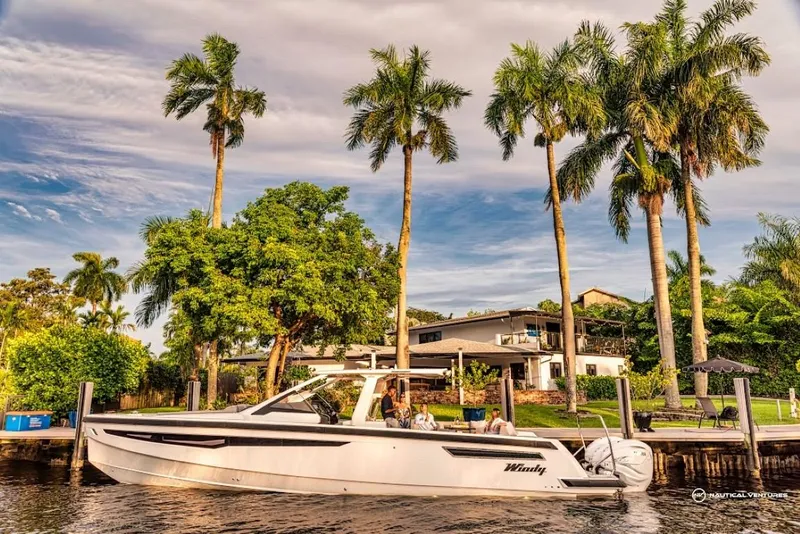 Slide: The Image of 2022 Windy SR44 SX boat docked near a tropical waterfront home with palm trees. - 8