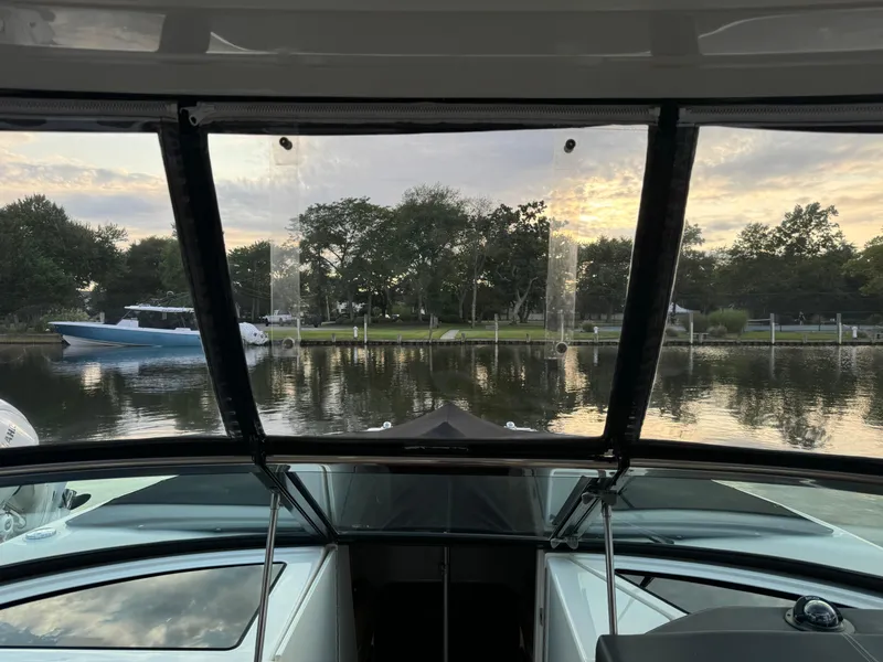 Slide: The Image of View from 2015 Sea Ray 350 SLX boat, overlooking serene waterfront and trees at sunset. - 21