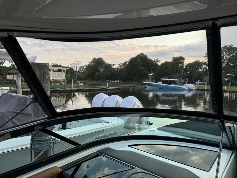 Slide: The Image of View from 2015 Sea Ray 350 SLX boat, overlooking serene waterfront and passing boat. - 22