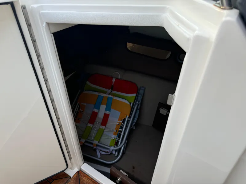 Slide: The Image of 2015 Sea Ray 350 SLX storage compartment with colorful folded beach chairs. - 47