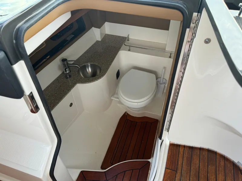 Slide: The Image of 2015 Sea Ray 350 SLX boat bathroom with sink and toilet, featuring wood flooring. - 34