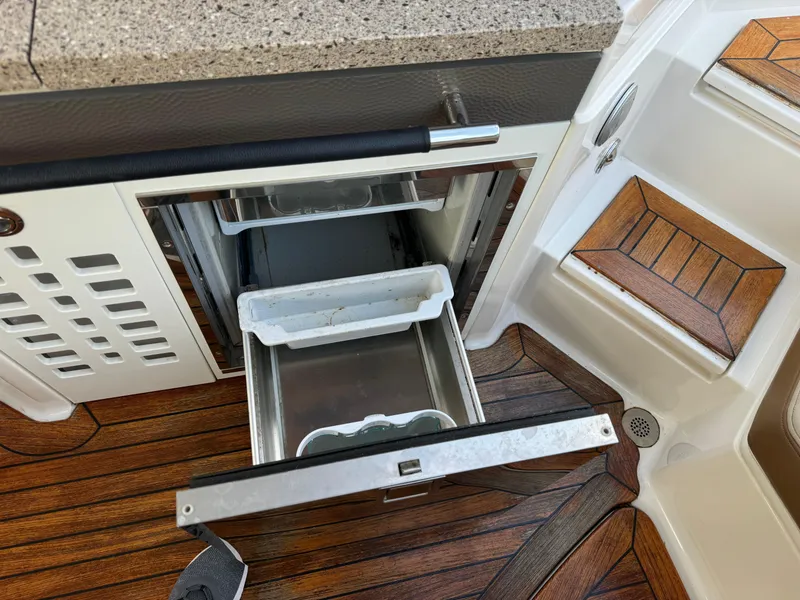 Slide: The Image of 2015 Sea Ray 350 SLX boat interior with open drawer and wooden flooring. - 13