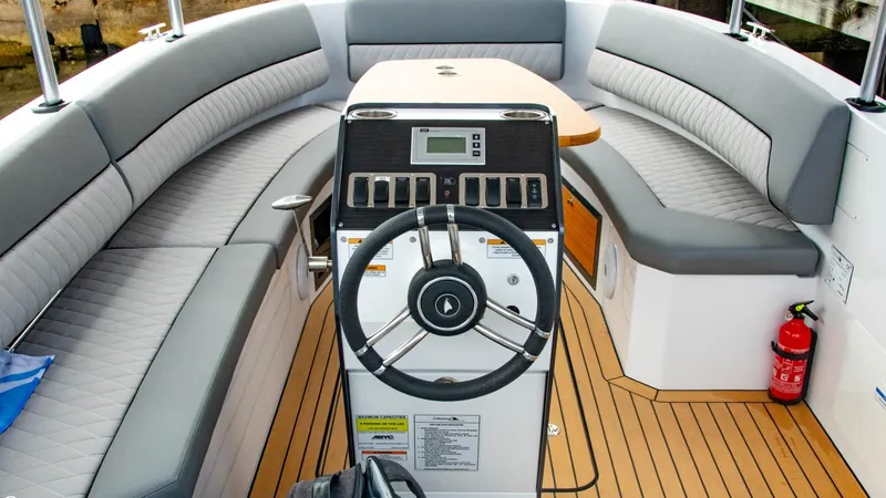 Slide: The Image of 2023 Alfastreet 21 Open boat interior with steering wheel and cushioned seating. - 22