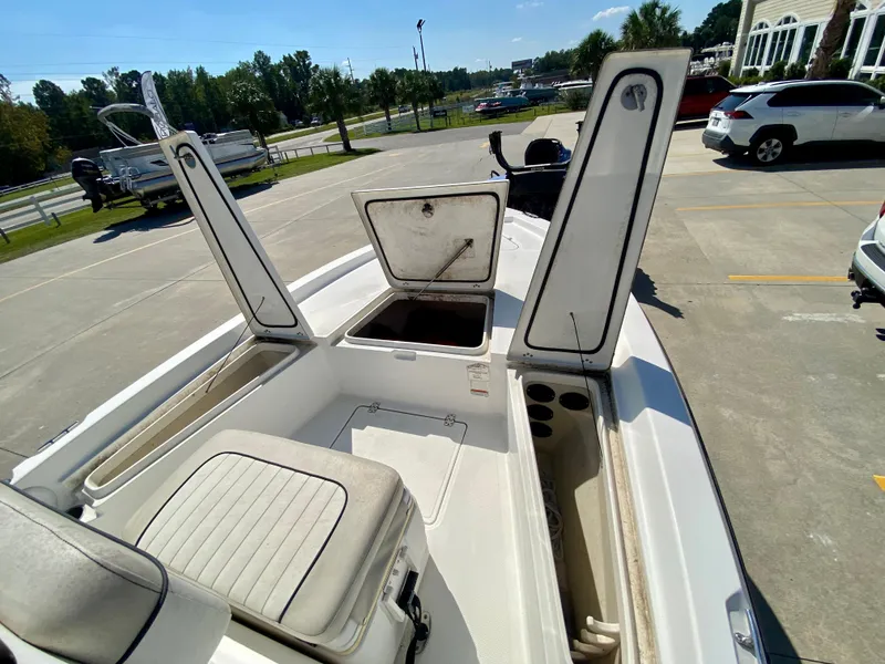 Slide: The Image of 2017 Mako 19 CPX boat with open storage compartments in a parking lot. - 16