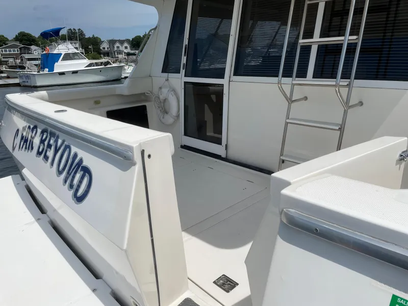 Slide: The Image of 1998 Bayliner 4788 Pilot House Motoryacht stern view with open deck and ladder. - 11