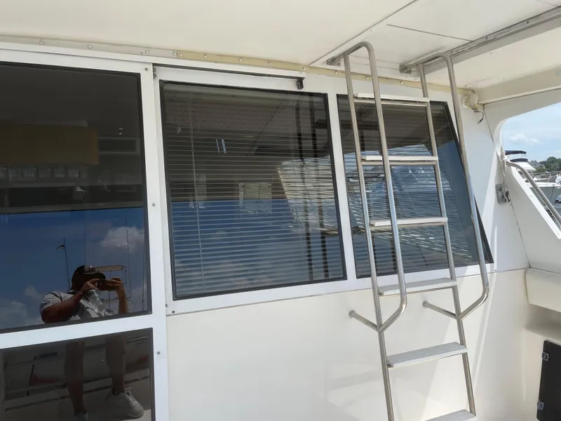 Slide: The Image of 1998 Bayliner 4788 Pilot House Motoryacht exterior with ladder and windows. - 14