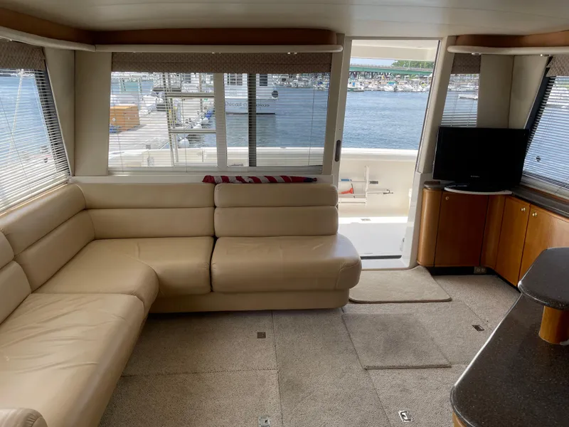 Slide: The Image of 1998 Bayliner 4788 Pilot House Motoryacht interior with beige leather seating and waterfront view. - 17