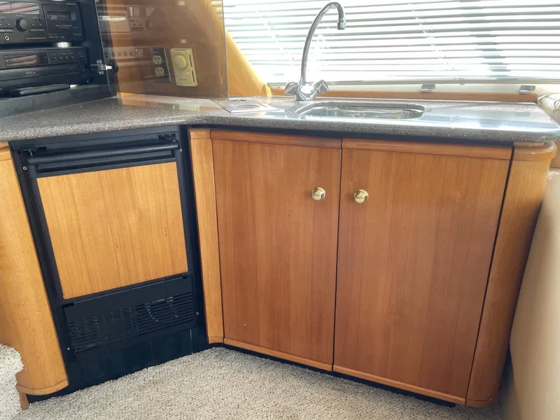 Slide: The Image of 1998 Bayliner 4788 Pilot House Motoryacht kitchen with sink, cabinets, and mini-fridge. - 20