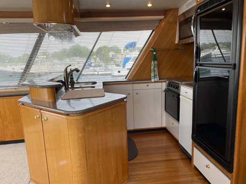 Slide: The Image of 1998 Bayliner 4788 Pilot House Motoryacht kitchen with wood cabinetry and modern appliances. - 21
