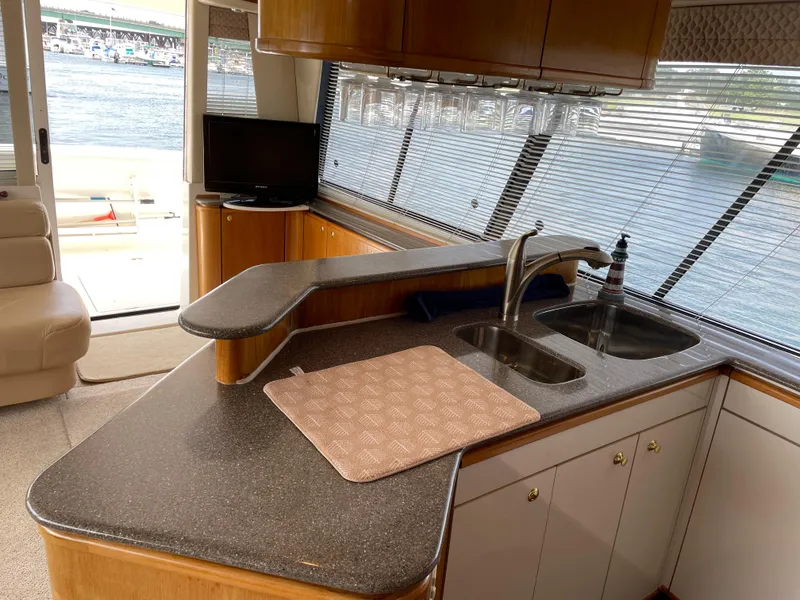 Slide: The Image of 1998 Bayliner 4788 Pilot House Motoryacht kitchen with double sink and waterfront view. - 22