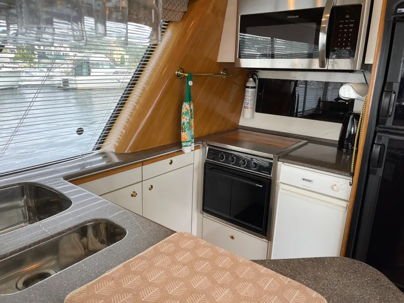 Slide: The Image of 1998 Bayliner 4788 Pilot House Motoryacht kitchen with stove, microwave, and sink. - 23