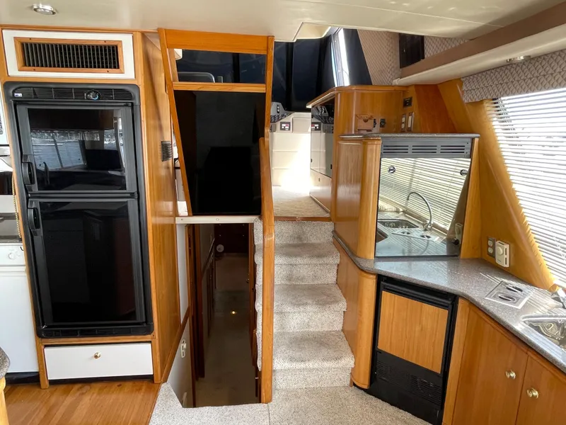 Slide: The Image of 1998 Bayliner 4788 Pilot House Motoryacht interior with kitchen, stairs, and appliances. - 24