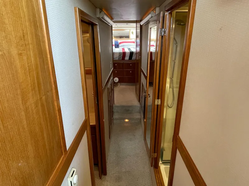 Slide: The Image of 1998 Bayliner 4788 Pilot House Motoryacht interior hallway with wood trim and carpet. - 25