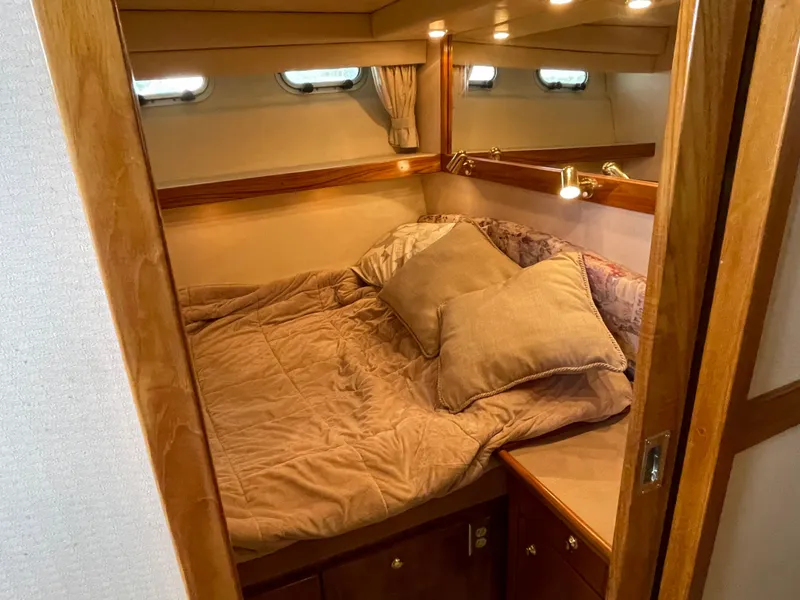 Slide: The Image of Cozy bedroom in 1998 Bayliner 4788 Pilot House Motoryacht with plush bedding and wooden accents. - 30